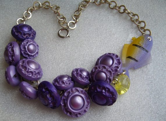 Vintage early plastic buttons and celluloid fish necklace.