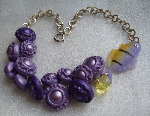 Vintage early plastic buttons and celluloid fish necklace.